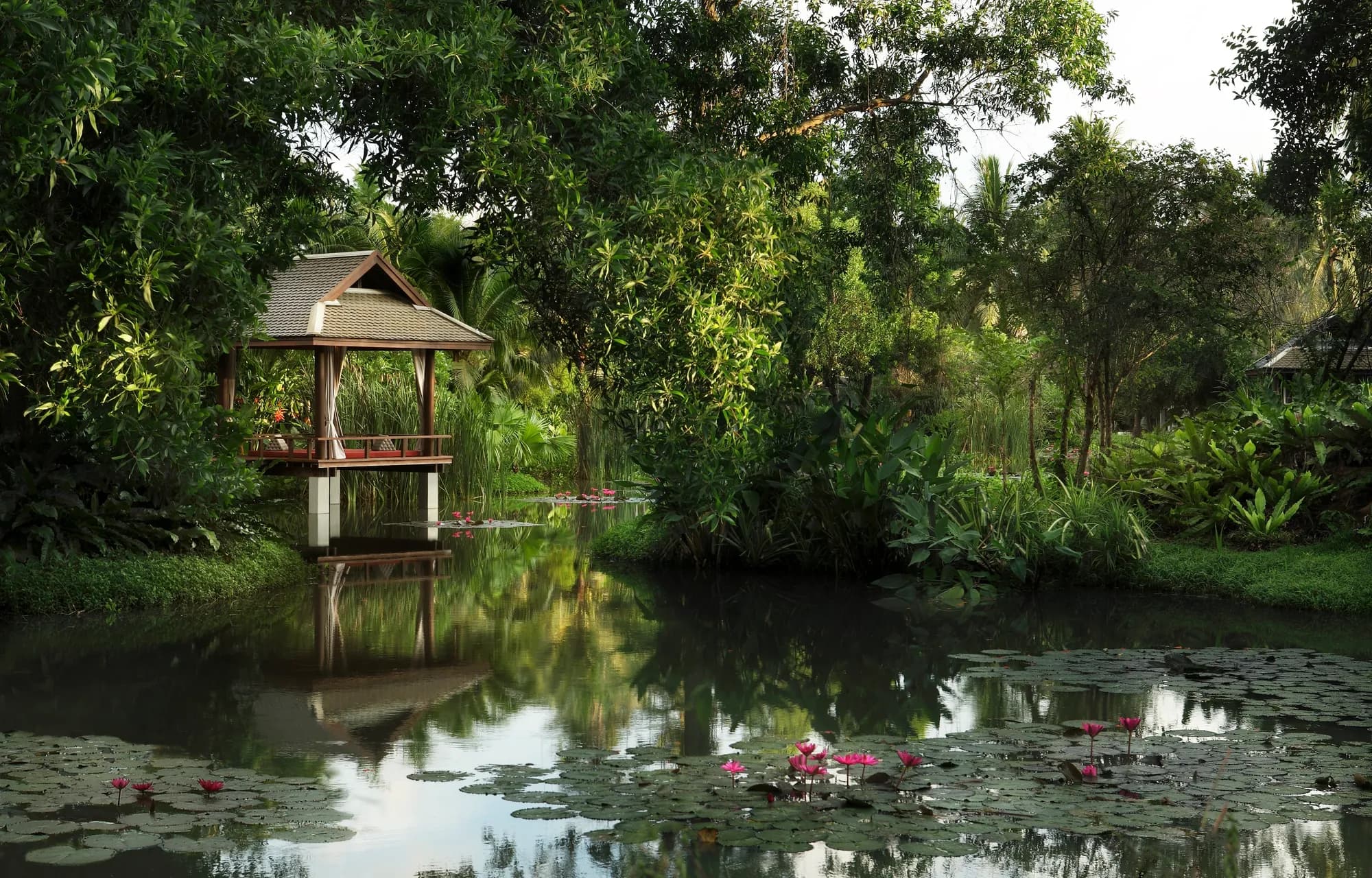 Lagoon-side garden lawn wedding setting framed by villas at Anantara Mai Khao Phuket Villas
