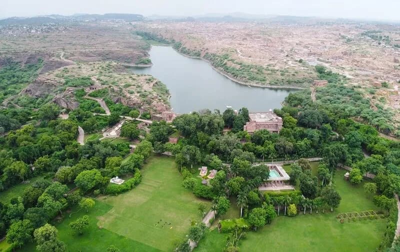 Red-sandstone 17th-century heritage palace facade overlooking Bal Samand Lake near Jodhpur