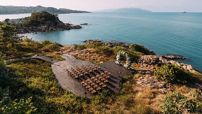 Cape Fahn sunset ceremony deck setup with rows of chairs and a floral arch on the headland Wedding Terrace, Gulf of Thailand