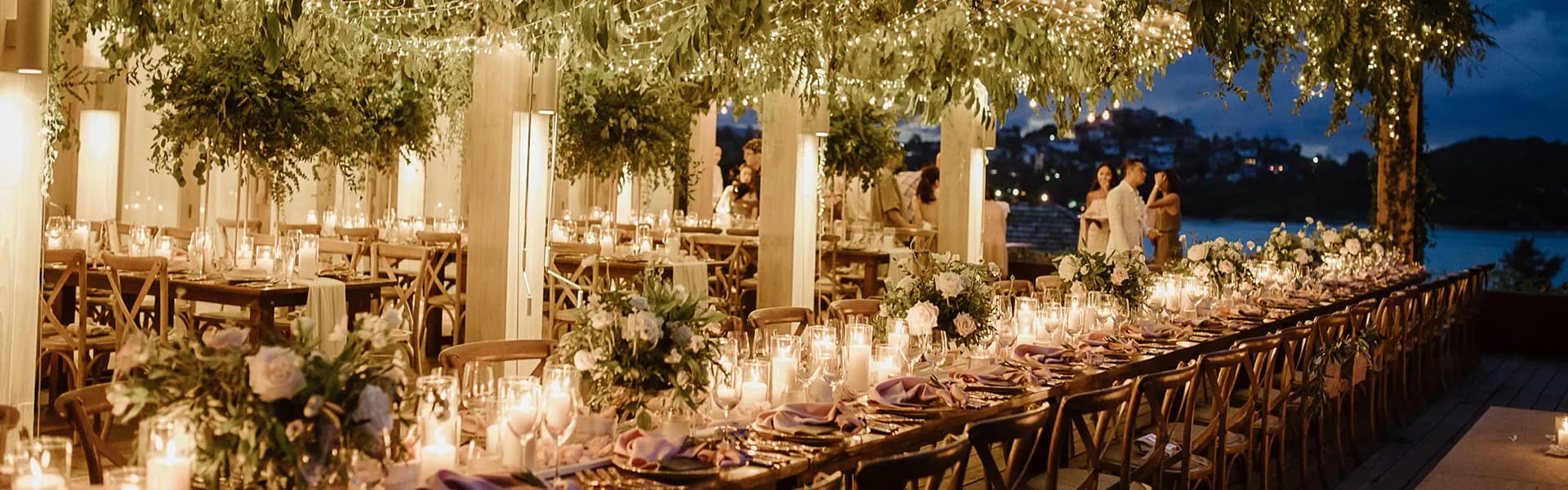 Cape Fahn candle-lit reception on the open-air Wedding Terrace at dusk with the Gulf of Thailand behind