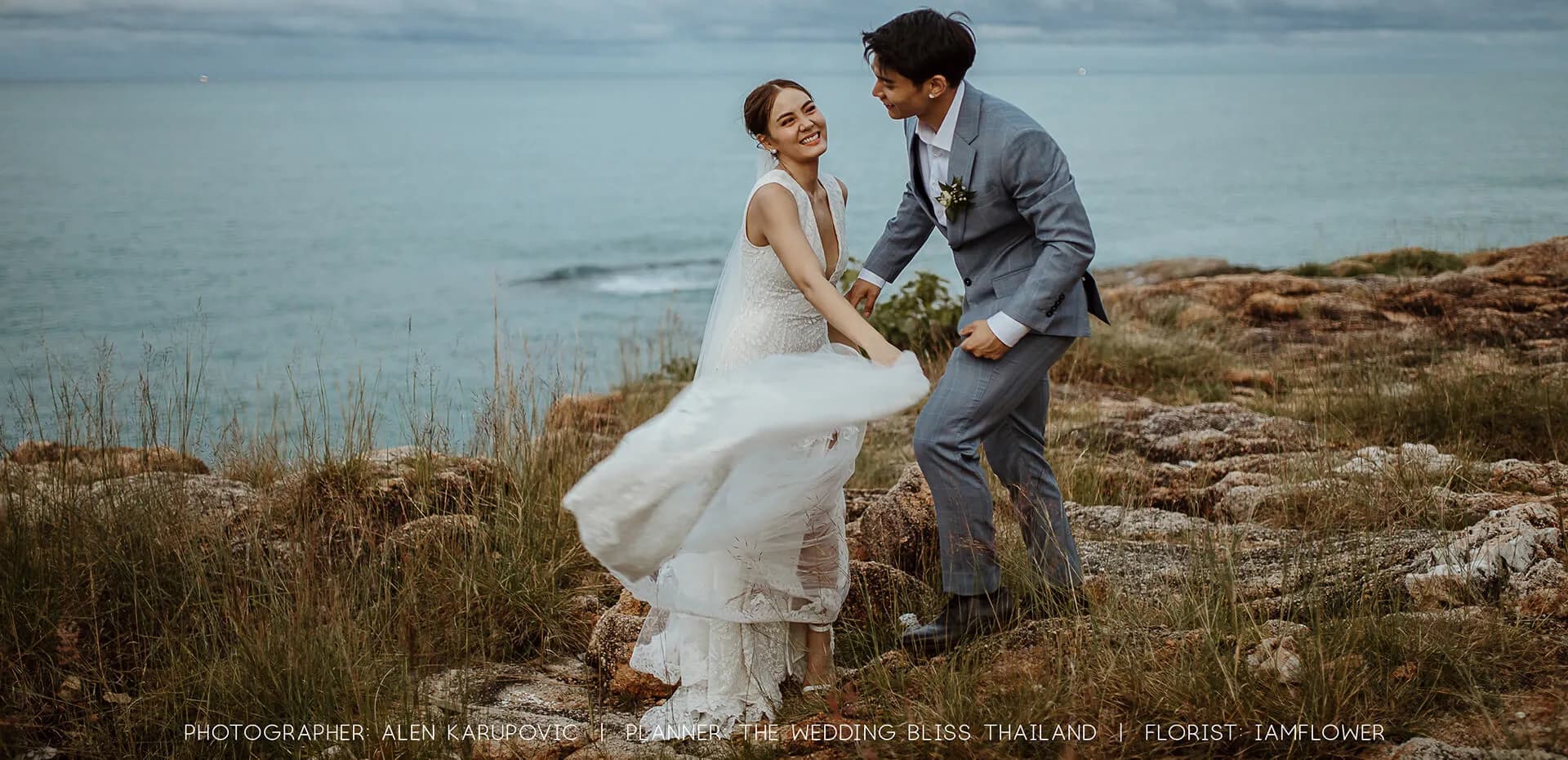 Cape Fahn couple beneath a white floral arch on the island headland deck over the Gulf of Thailand at sunset, Koh Samui private island