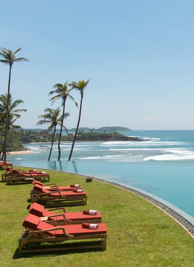 Cape Weligama clifftop crescent Moon Pool overlooking the Indian Ocean at sunset on Sri Lanka's south coast