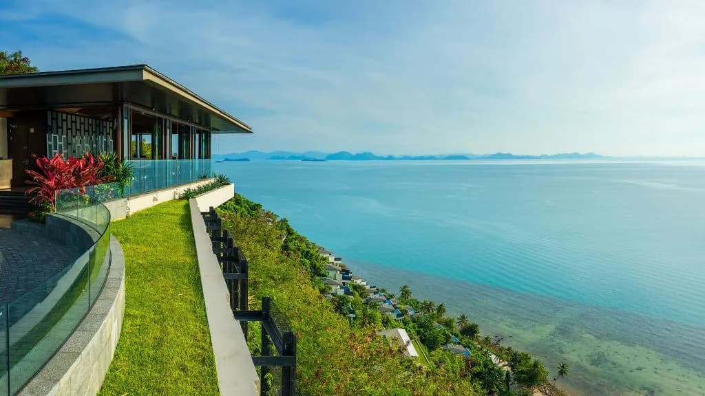 Conrad Koh Samui clifftop pool villas glowing above the Gulf of Thailand at dusk, Taling Ngam, Koh Samui