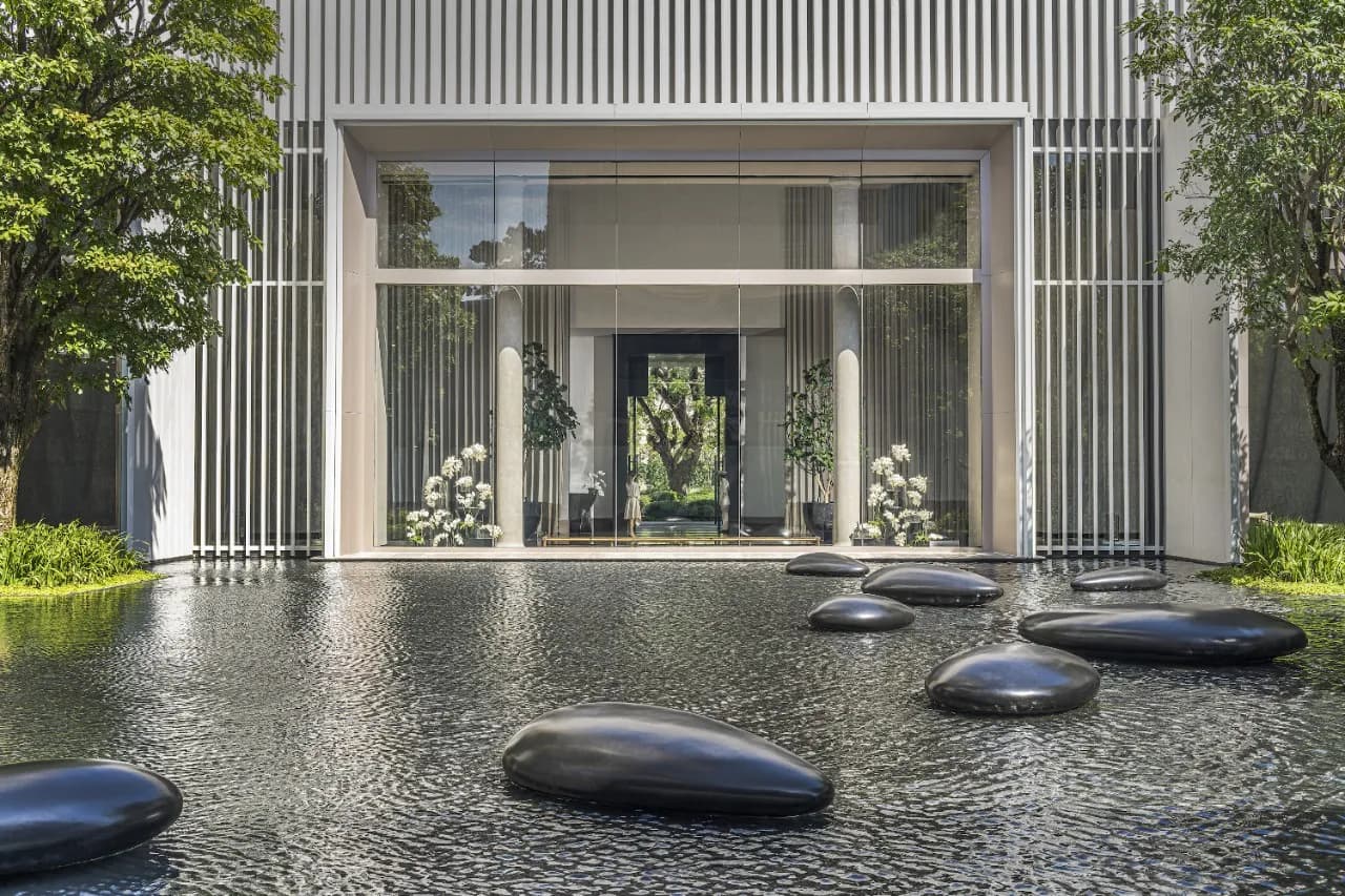 Architectural arrival entrance with reflecting pond and stone sculptures at Four Seasons Hotel Bangkok at Chao Phraya River