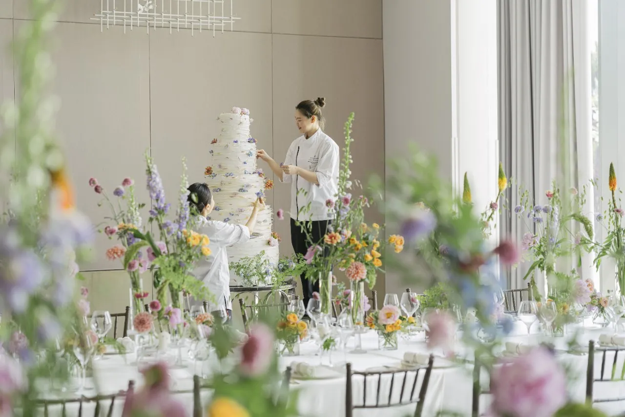 Ballroom styled with wildflower installations and a tiered wedding cake at Four Seasons Hotel Bangkok