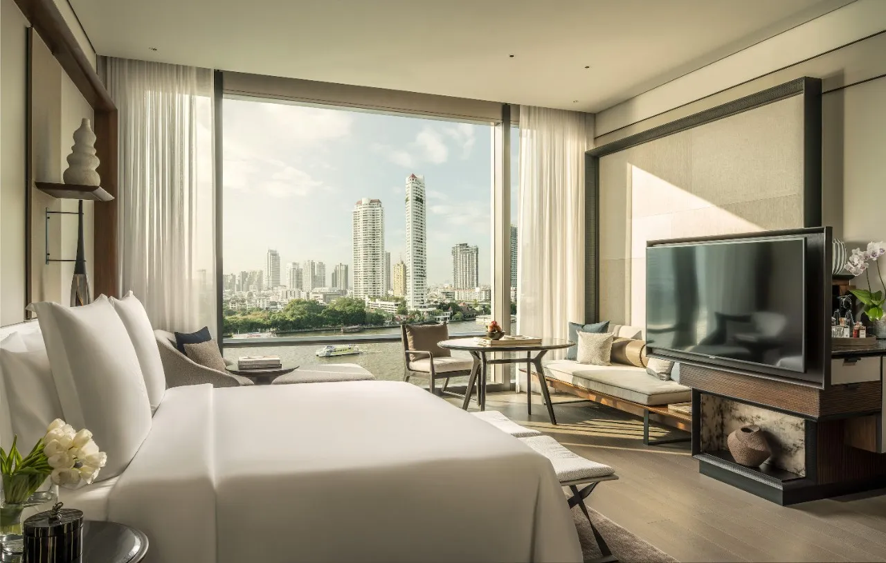 Contemporary guest room with floor-to-ceiling windows over the Chao Phraya River and Bangkok skyline at Four Seasons Bangkok