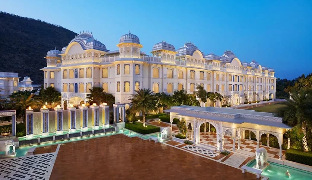 Grand arrival courtyard with carved archways and water features at The Leela Palace Jaipur