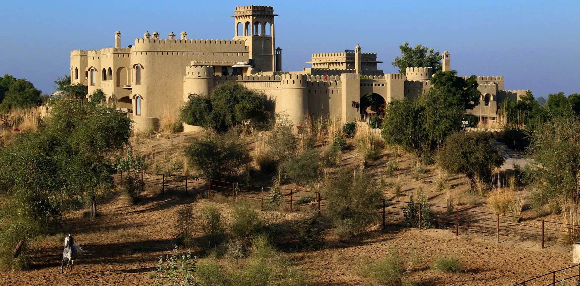 Mihir Garh desert fort hotel standing on a sand dune in the Thar Desert near Jodhpur at golden hour