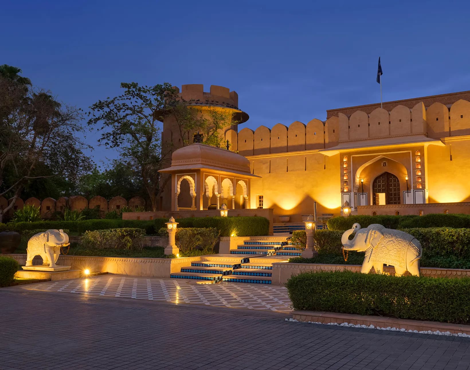The Oberoi Rajvilas Jaipur fort-style architecture and landscaped Charbagh gardens at dusk