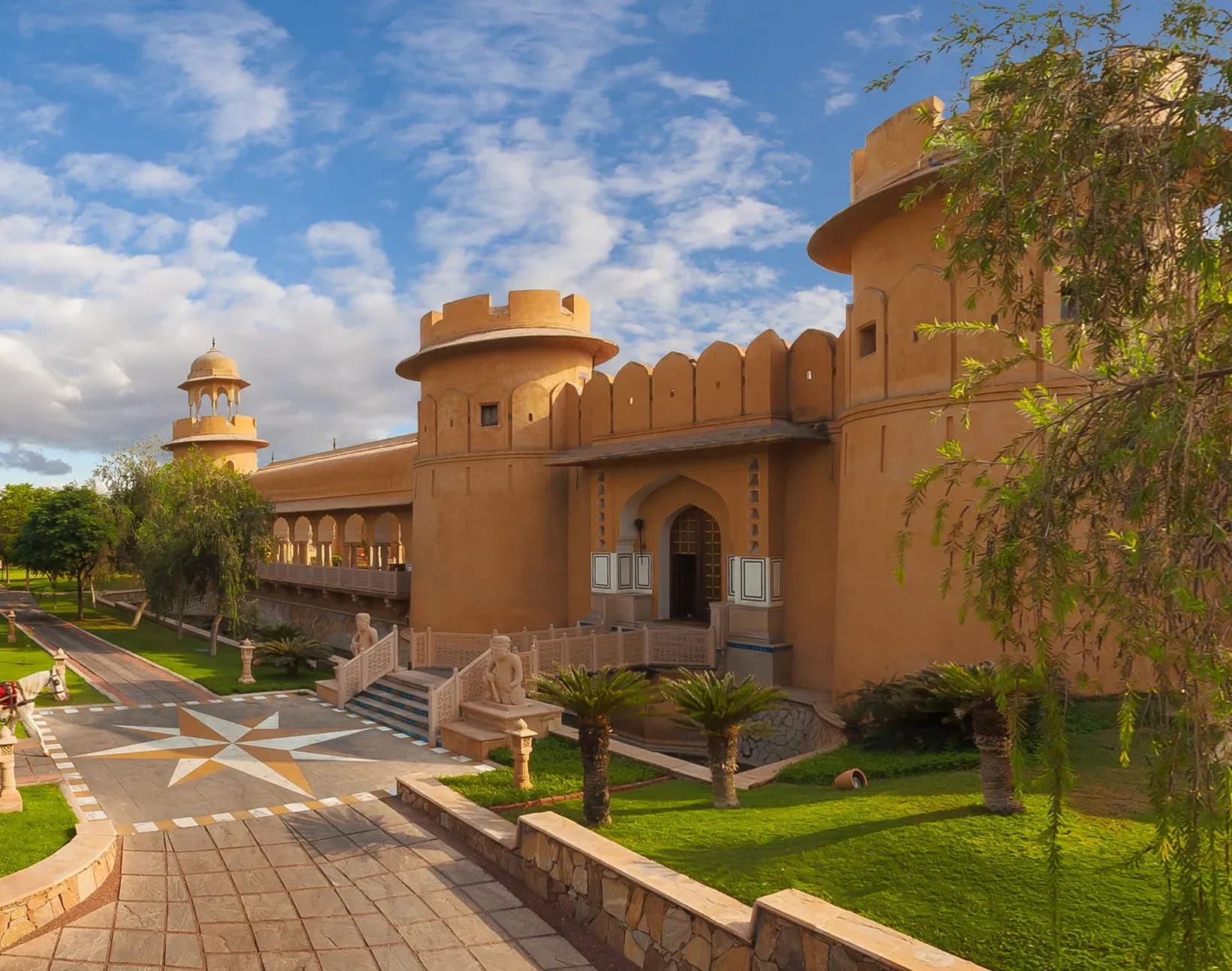 Walled fort-style arrival forecourt and reflection pool at The Oberoi Rajvilas Jaipur