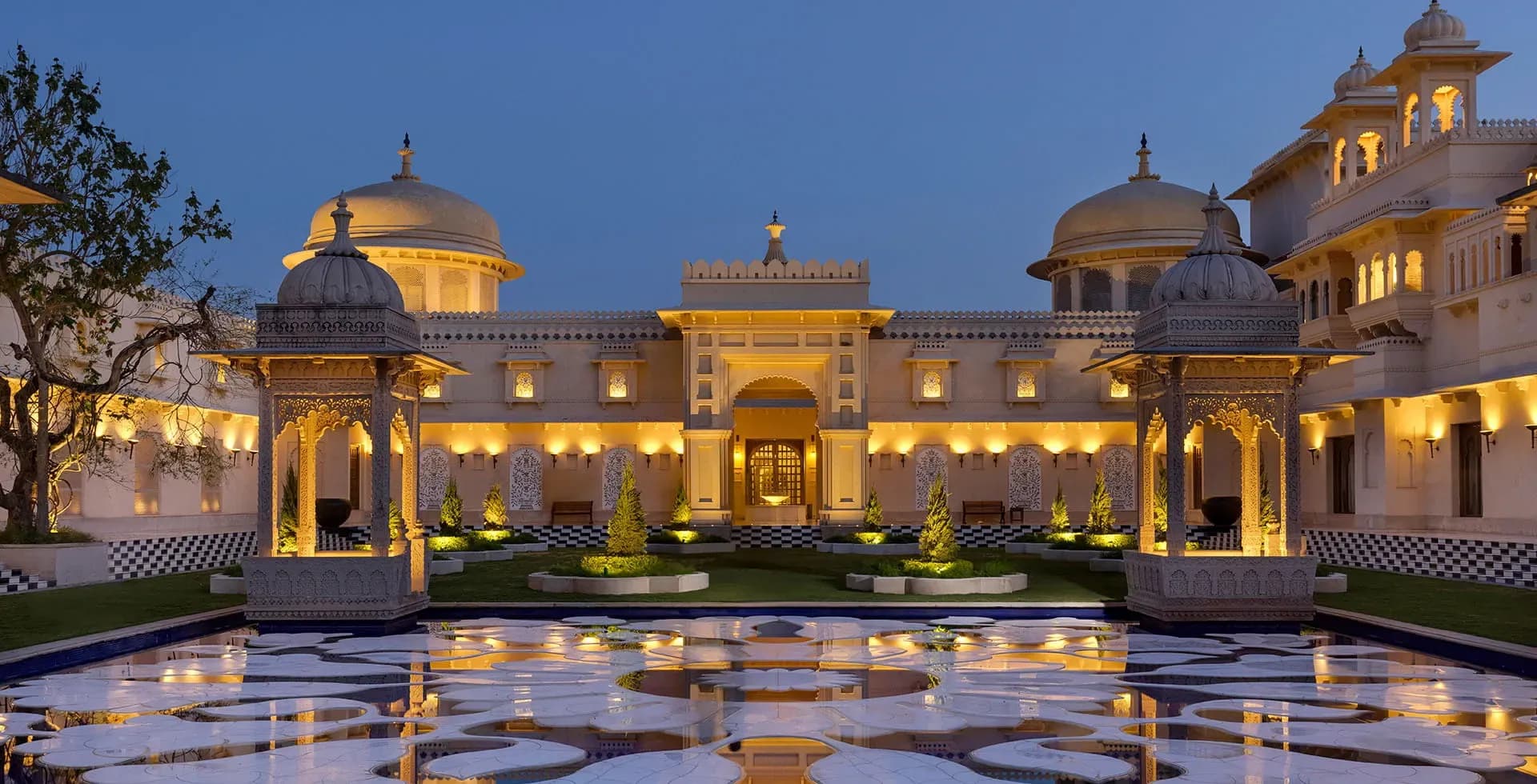 Aerial-style view of The Oberoi Udaivilas palace domes beside Lake Pichola in Udaipur