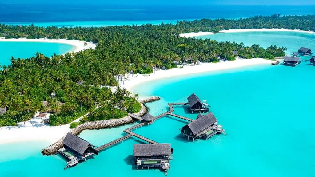 Aerial view of One&Only Reethi Rah private island, white-sand beaches and over-water villas on turquoise lagoon, North Male Atoll Maldives