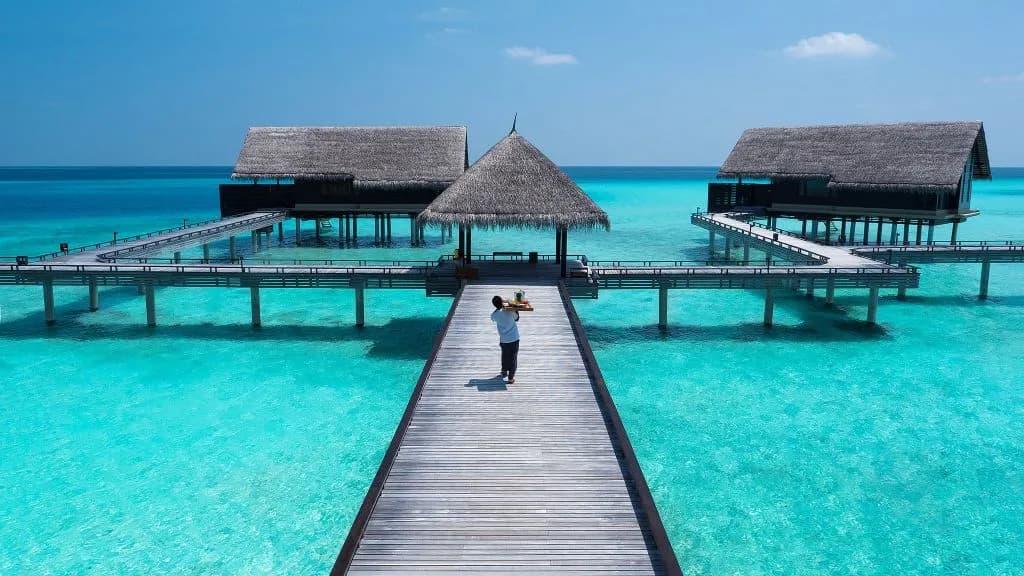 Aerial view of One&Only Reethi Rah water villa cluster on jetties over the lagoon, Maldives