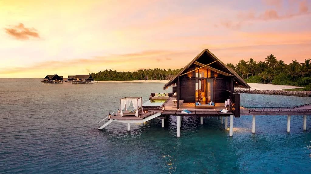 Aerial view of One&Only Reethi Rah over-water villas with pools on turquoise lagoon, North Male Atoll Maldives