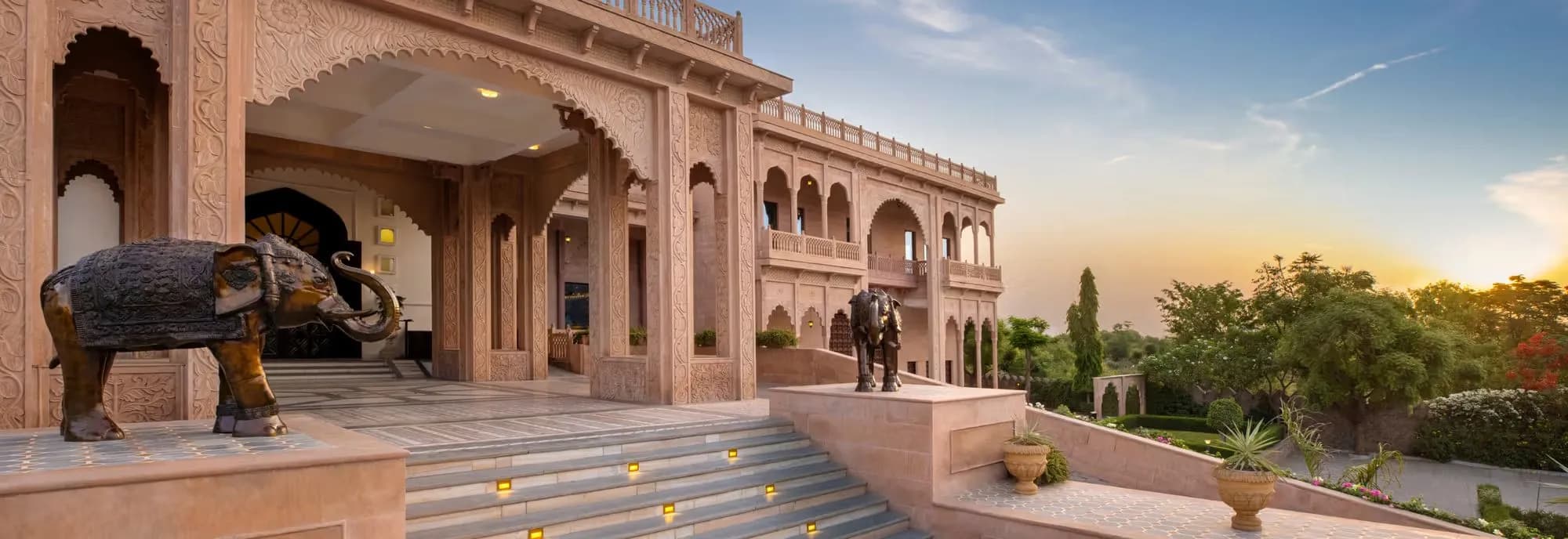Arrival porte-cochère with brass elephants and arched portico at Pratap Mahal Ajmer IHCL SeleQtions at sunset
