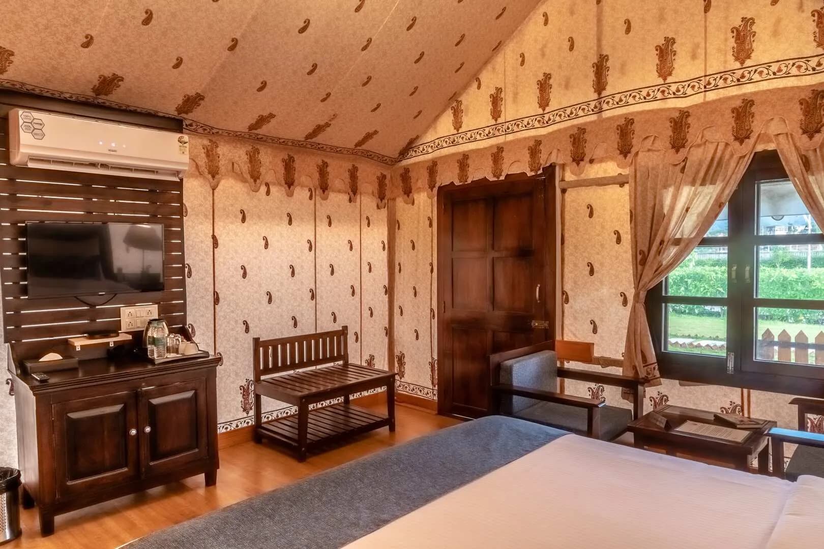 Interior of a Swiss-cottage luxury tent with natural-stone bathtub at Rawai Luxury Tents Pushkar