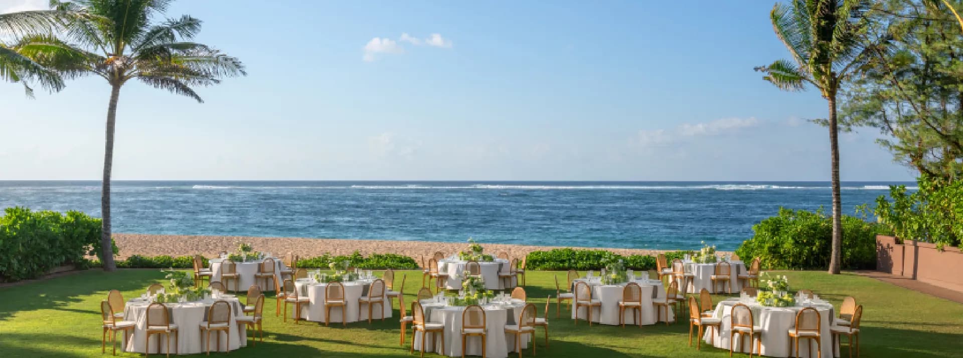 Beachfront lawn set with round dinner tables overlooking the Indian Ocean at The St. Regis Bali Resort, Nusa Dua, Bali