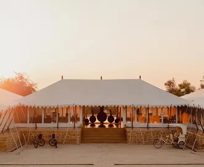 SUJÁN The Serai luxury tented camp with white canvas suites on honey-hued sandstone plinths across the Thar Desert near Jaisalmer