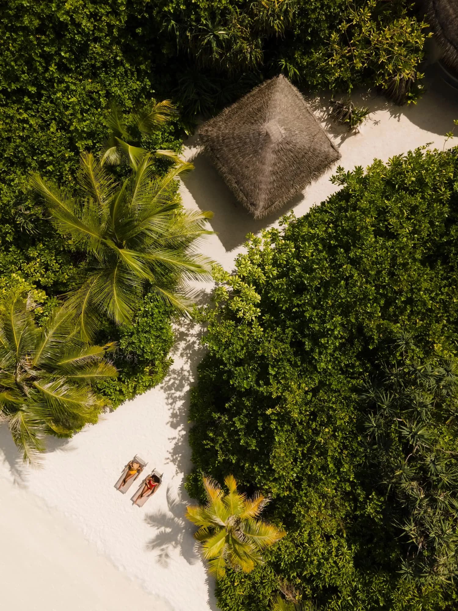 Aerial view of Sun Siyam Iru Fushi private island, jetty and over-water villas in the Noonu Atoll lagoon, Maldives