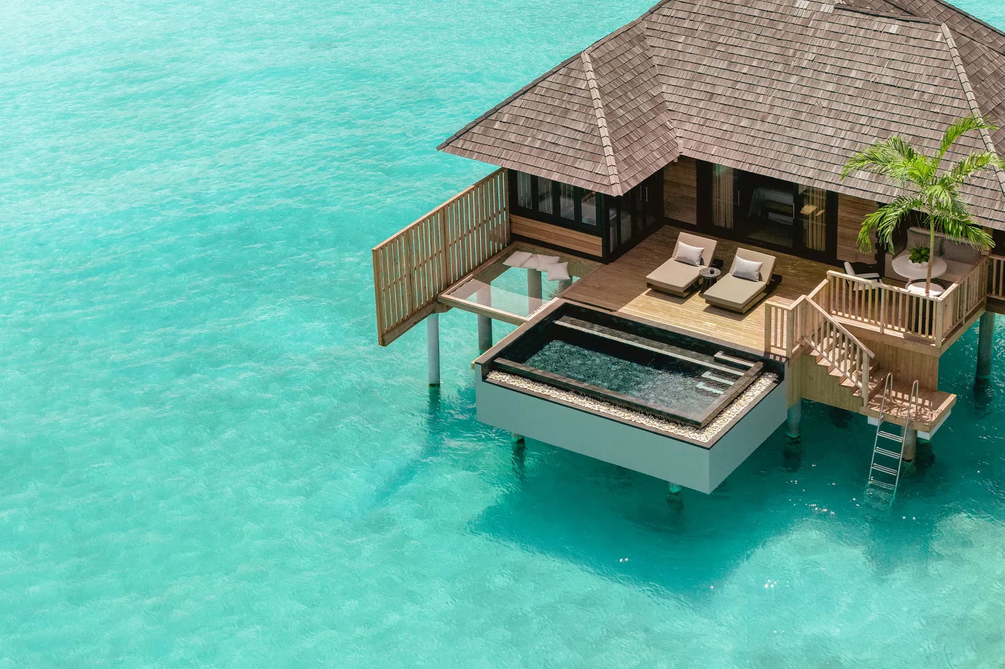 Over-water villa with private pool on stilts above the turquoise lagoon at Sun Siyam Iru Fushi, Maldives