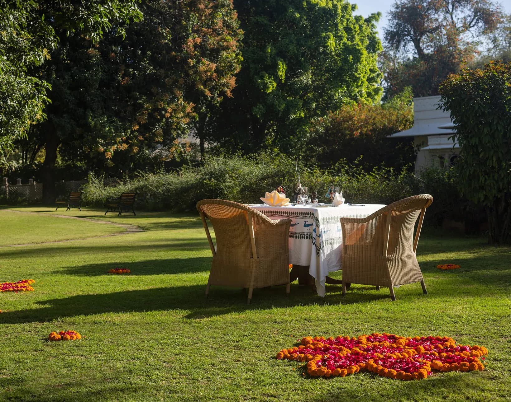 Walled mango orchard set with candlelit dining tables for an event at The Oberoi Vanyavilas Ranthambore