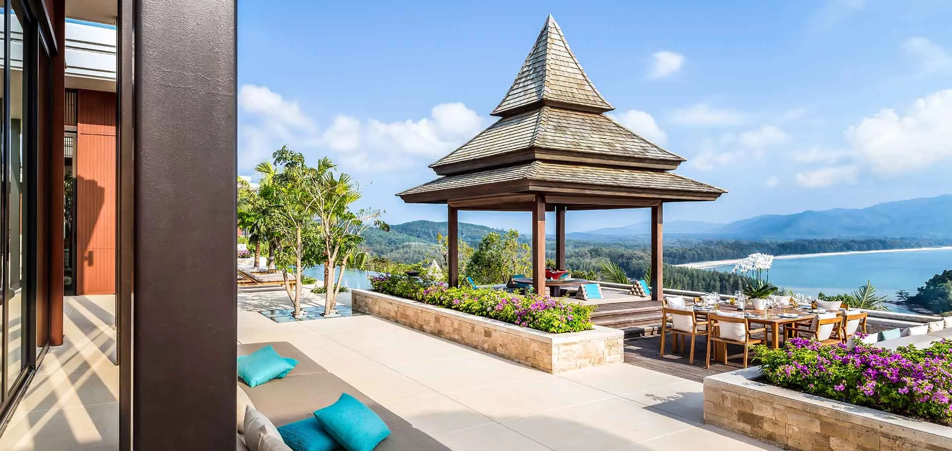 Anantara Layan Phuket Resort swimming pool and the Layan Beach cove glowing at dusk on the Andaman coast