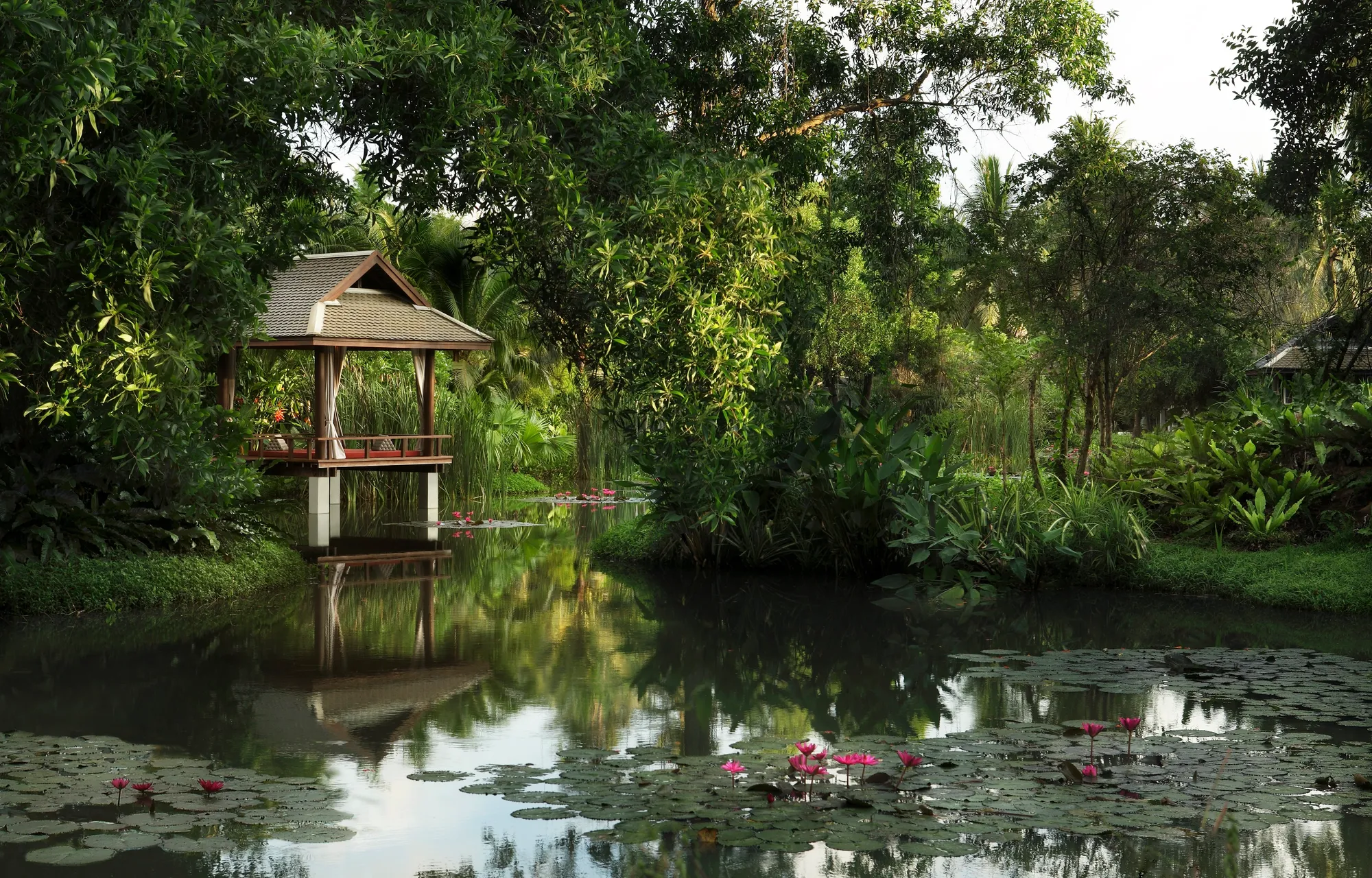 Lagoon-side garden lawn wedding setting framed by villas at Anantara Mai Khao Phuket Villas