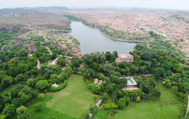 Red-sandstone 17th-century heritage palace facade overlooking Bal Samand Lake near Jodhpur