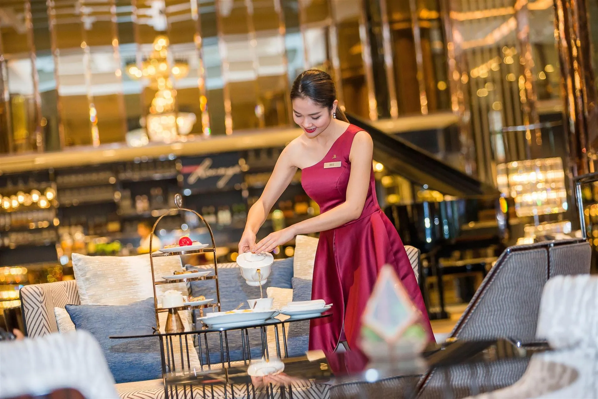 Lobby lounge afternoon tea service with a host pouring tea at Bangkok Marriott Marquis Queen's Park