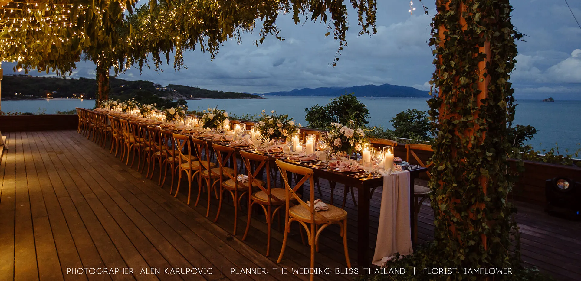Cape Fahn long candle-lit wedding dinner table on the open-air terrace deck overlooking the Gulf of Thailand at dusk