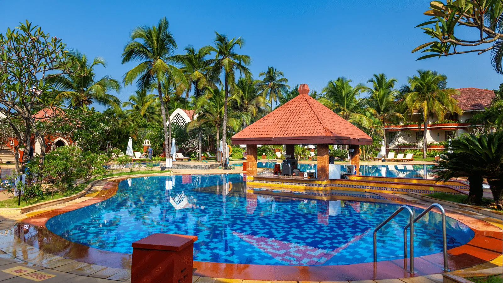 Outdoor swimming pool and swim-up bar at Caravela Beach Resort Goa