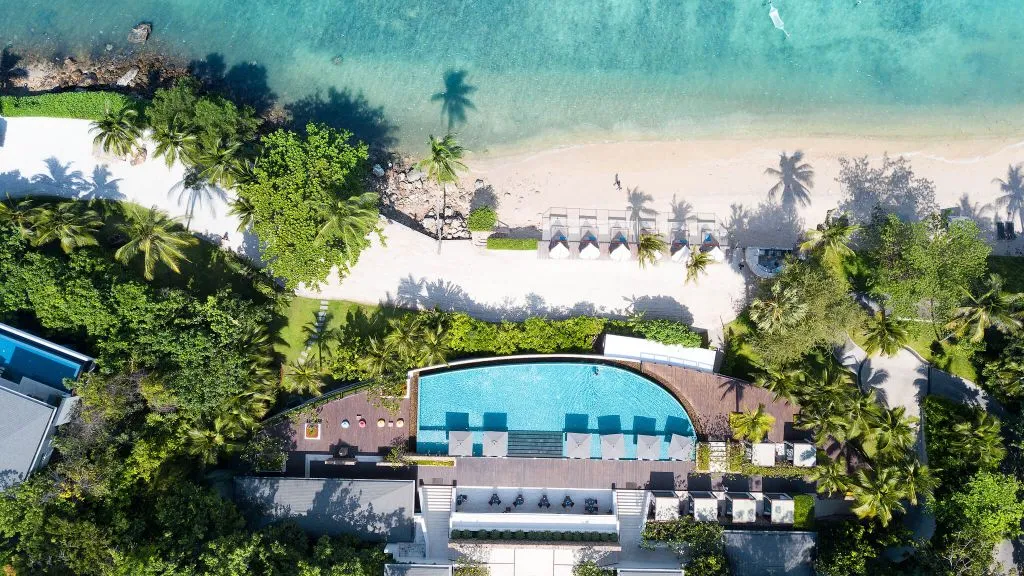 Aerial view of the main infinity pool reaching toward the Gulf of Thailand at Conrad Koh Samui