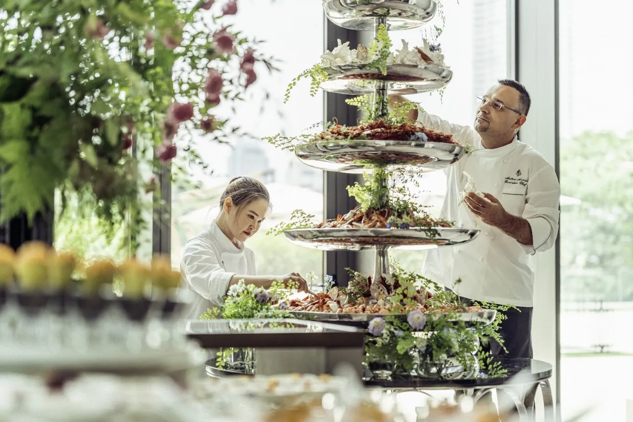 Four Seasons chefs styling a tiered seafood tower beside the river at Four Seasons Hotel Bangkok