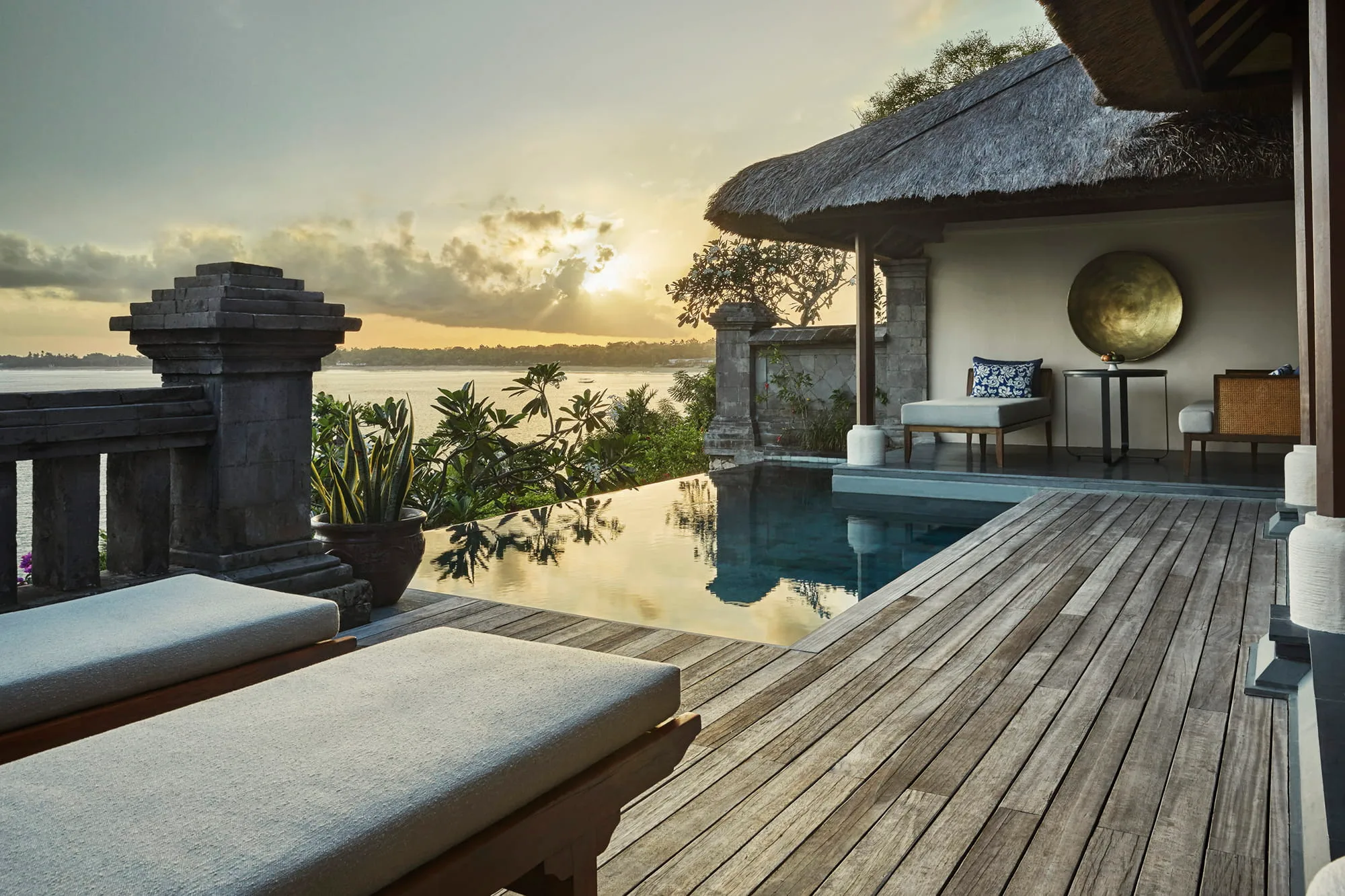 Four Seasons Resort Bali at Jimbaran Bay private cove and Jimbaran Bay coastline at golden-hour sunset on Bali's west coast
