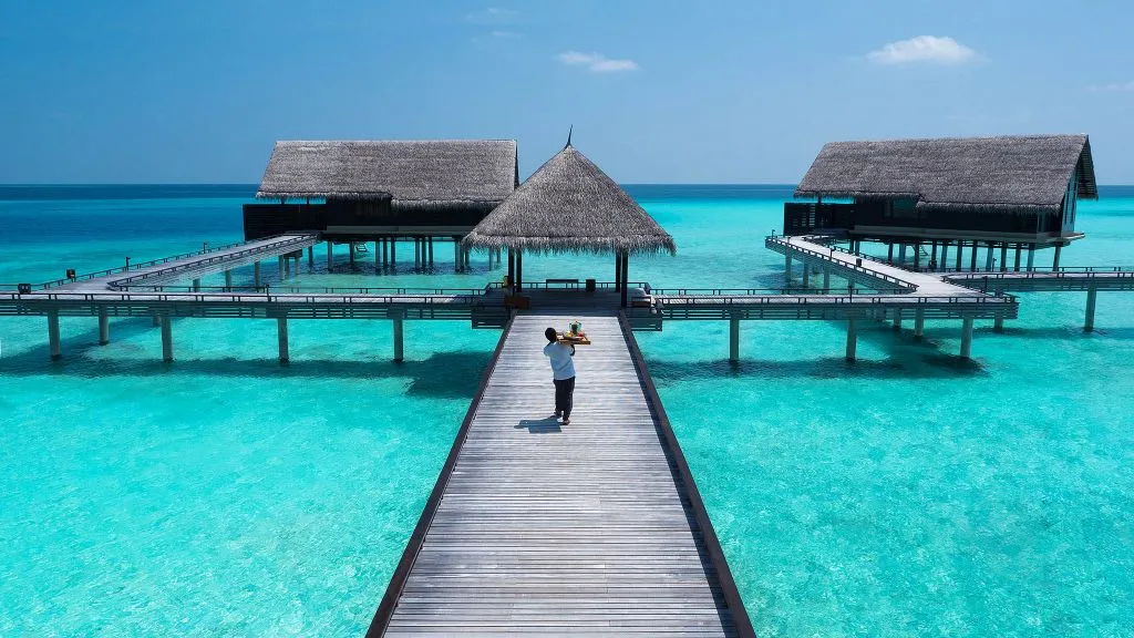 Aerial view of One&Only Reethi Rah water villa cluster on jetties over the lagoon, Maldives