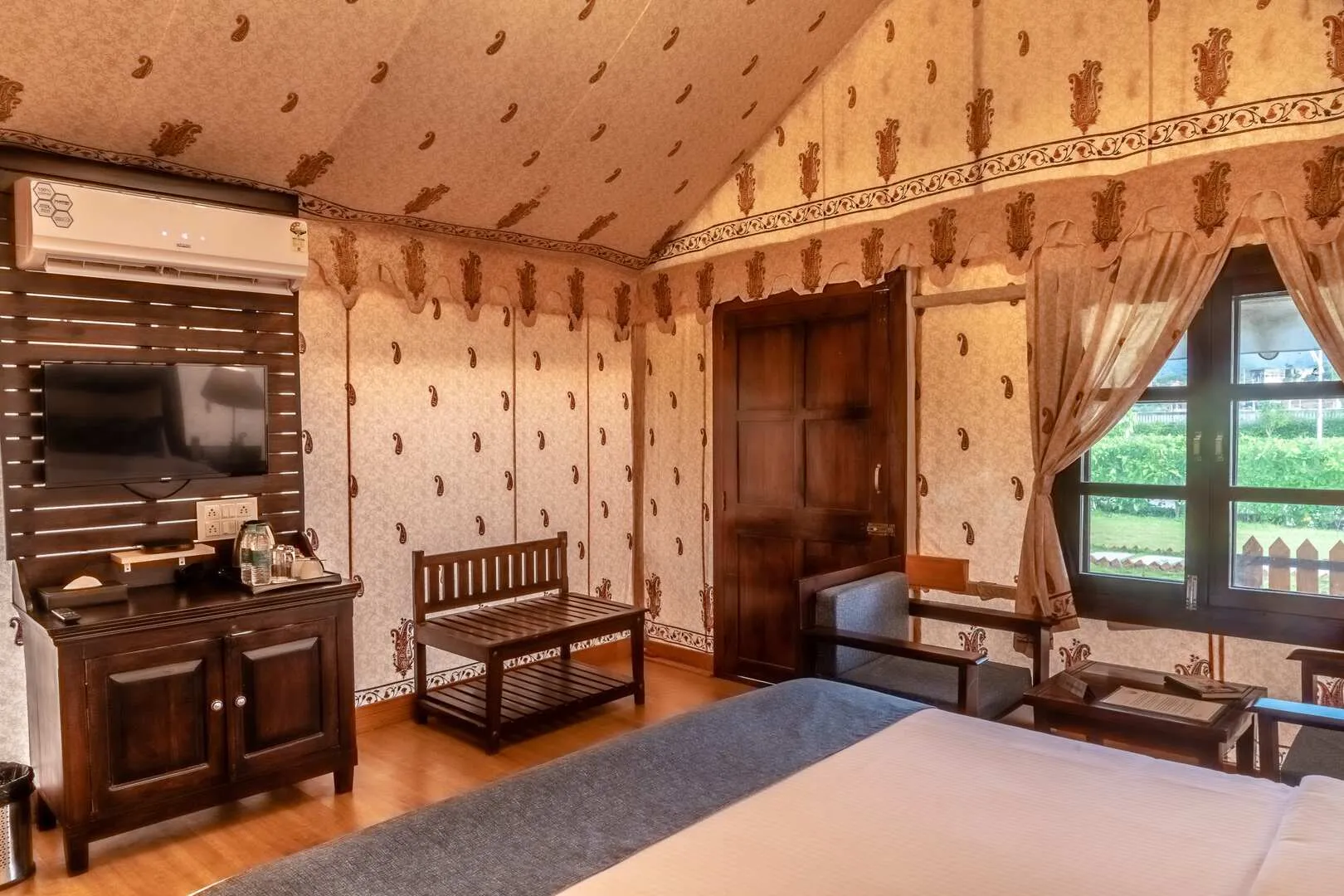 Interior of a Swiss-cottage luxury tent with natural-stone bathtub at Rawai Luxury Tents Pushkar