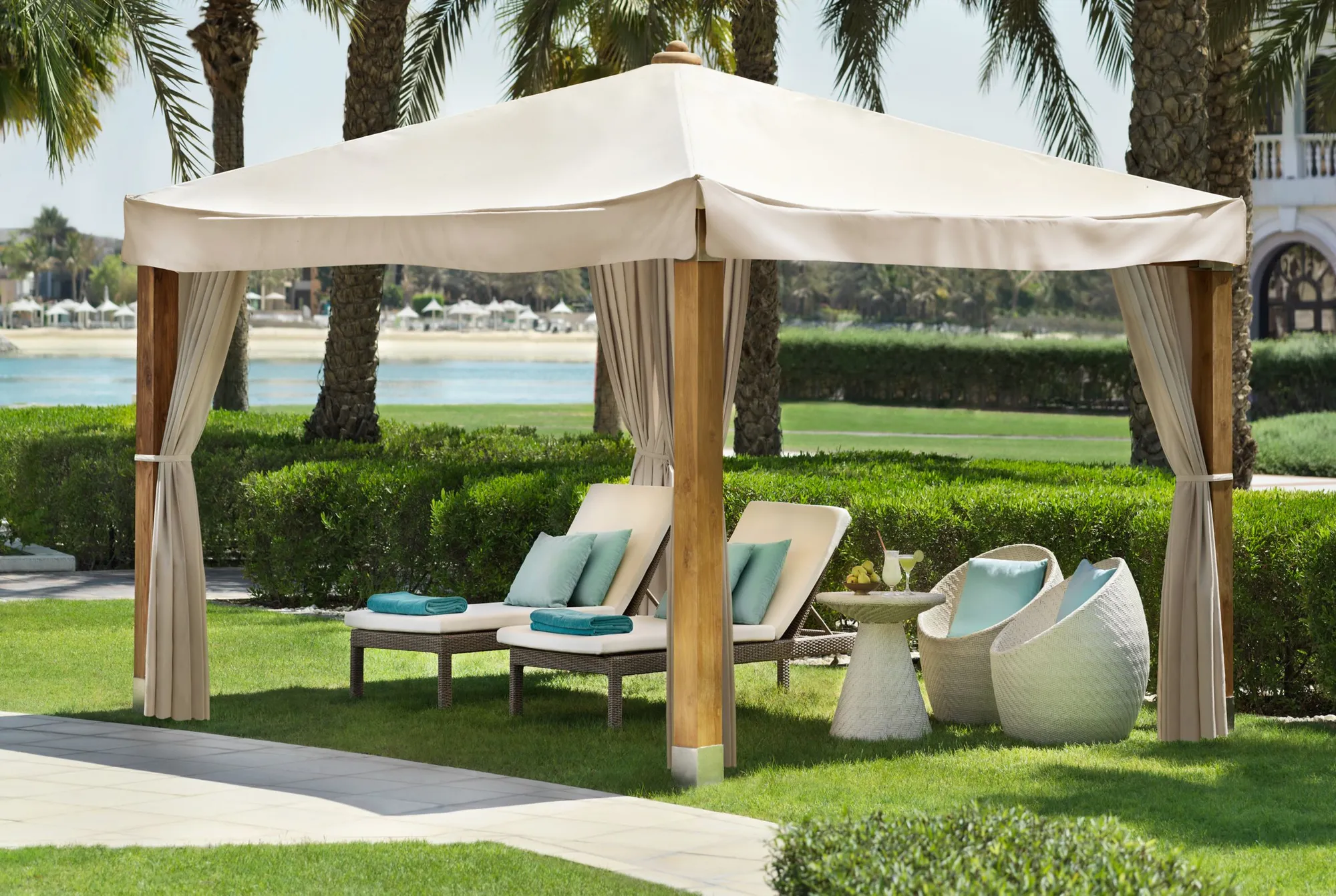 Private teak garden cabana with daybeds beside the lagoon at The Ritz-Carlton Abu Dhabi Grand Canal