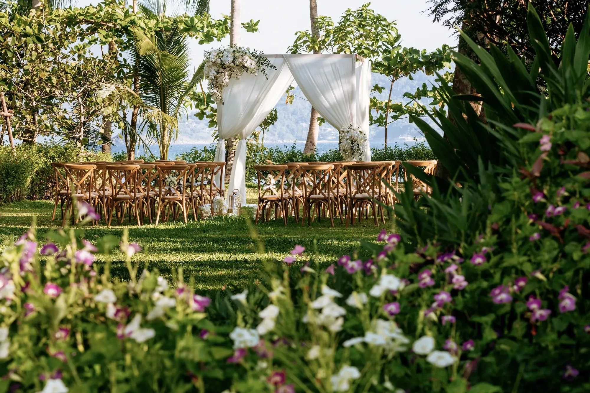 Wedding ceremony setup on the garden lawn above the sea at Rosewood Phuket, Emerald Bay Phuket