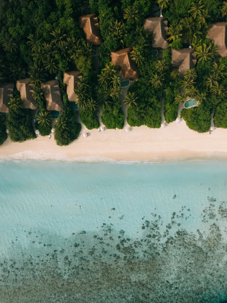 Aerial view of Soneva Fushi private island and turquoise lagoon in the Baa Atoll, Maldives