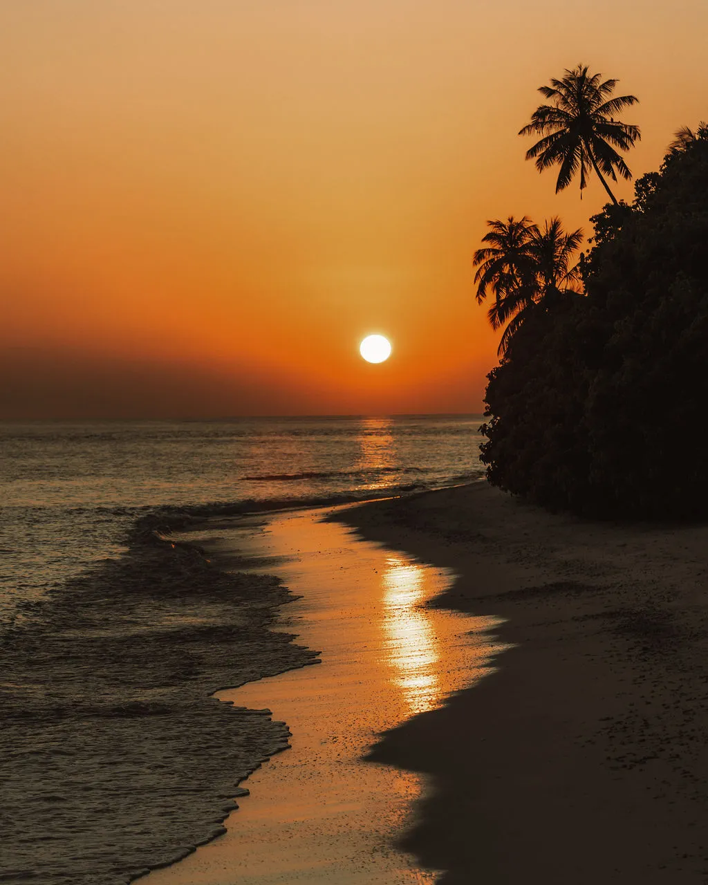 Sunset over the beach at Soneva Fushi, a barefoot wedding ceremony setting in the Maldives