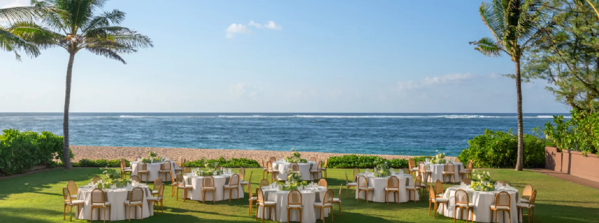 Beachfront lawn set with round dinner tables overlooking the Indian Ocean at The St. Regis Bali Resort, Nusa Dua, Bali