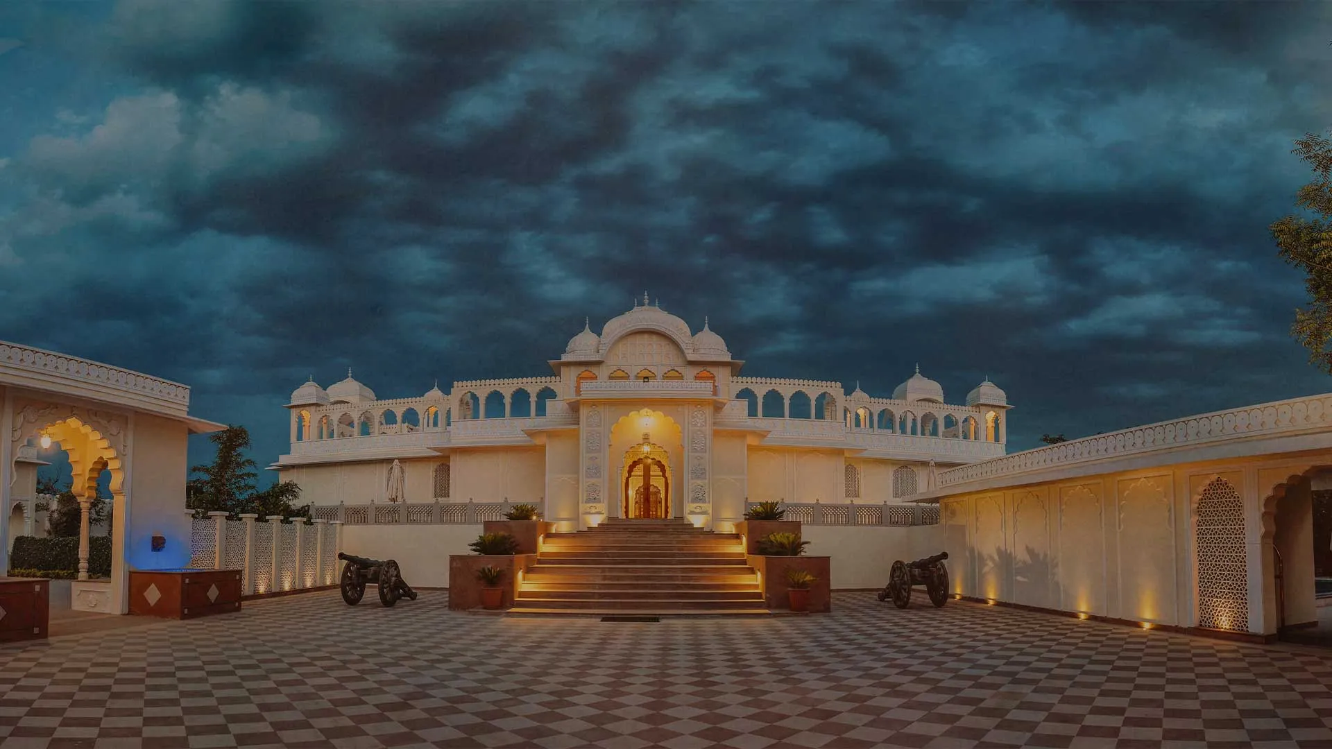 The Tigress Ranthambore heritage-style resort facade with arches and lawns on the edge of Ranthambore National Park