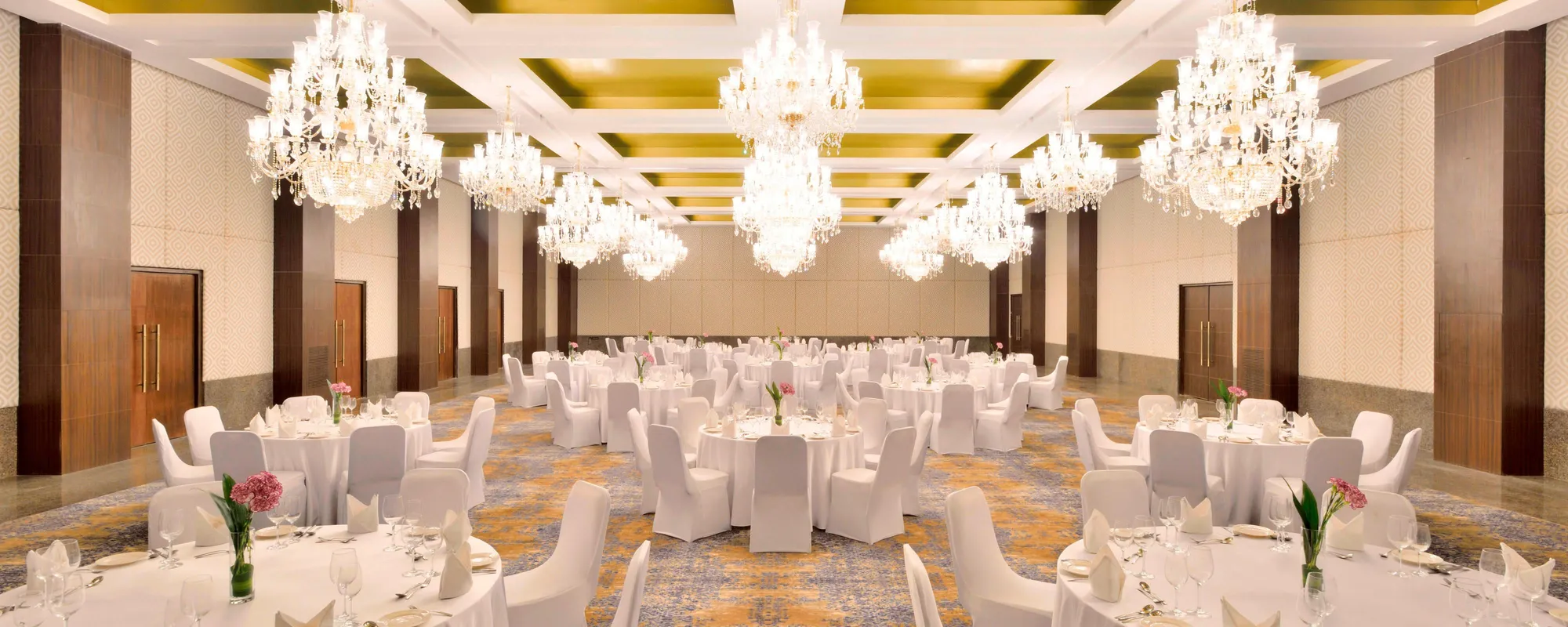 The Royal Ballroom set for a banquet with crystal chandeliers and gold ceiling at The Westin Pushkar Resort & Spa