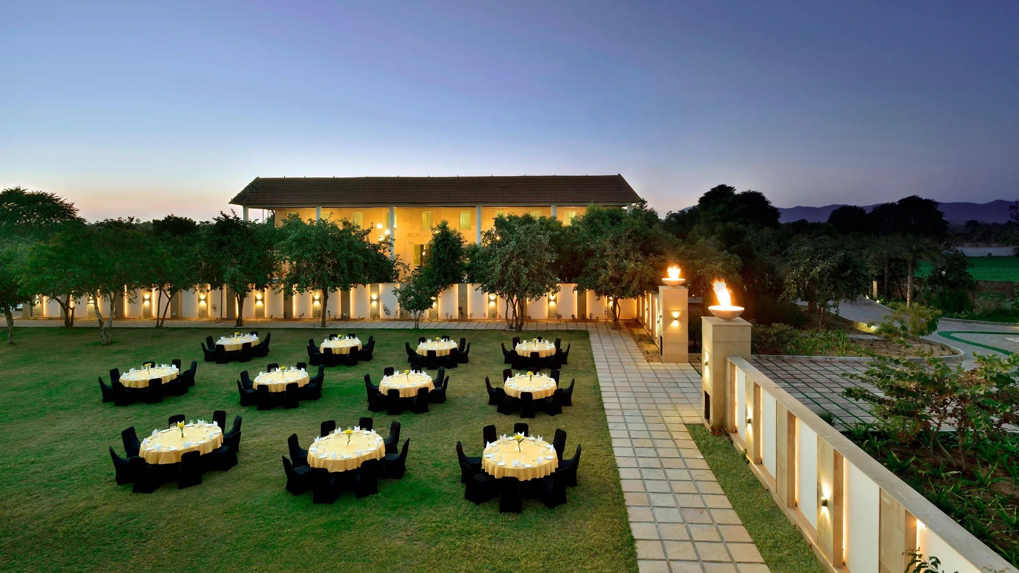 Wide manicured wedding lawn framed by palms and the Aravalli hills at The Westin Pushkar Resort & Spa