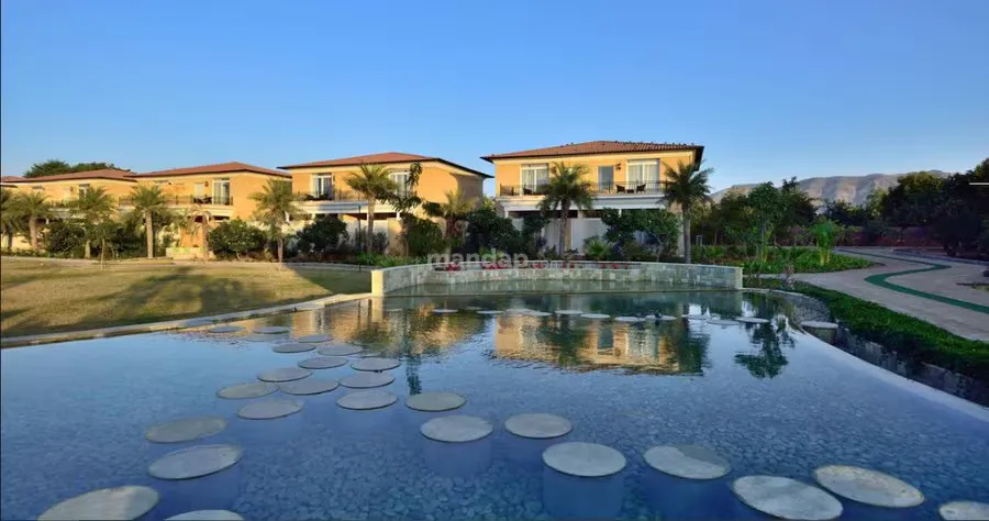 The Westin Pushkar Resort & Spa villas and grounds glowing at dusk below the Aravalli hills, Pushkar